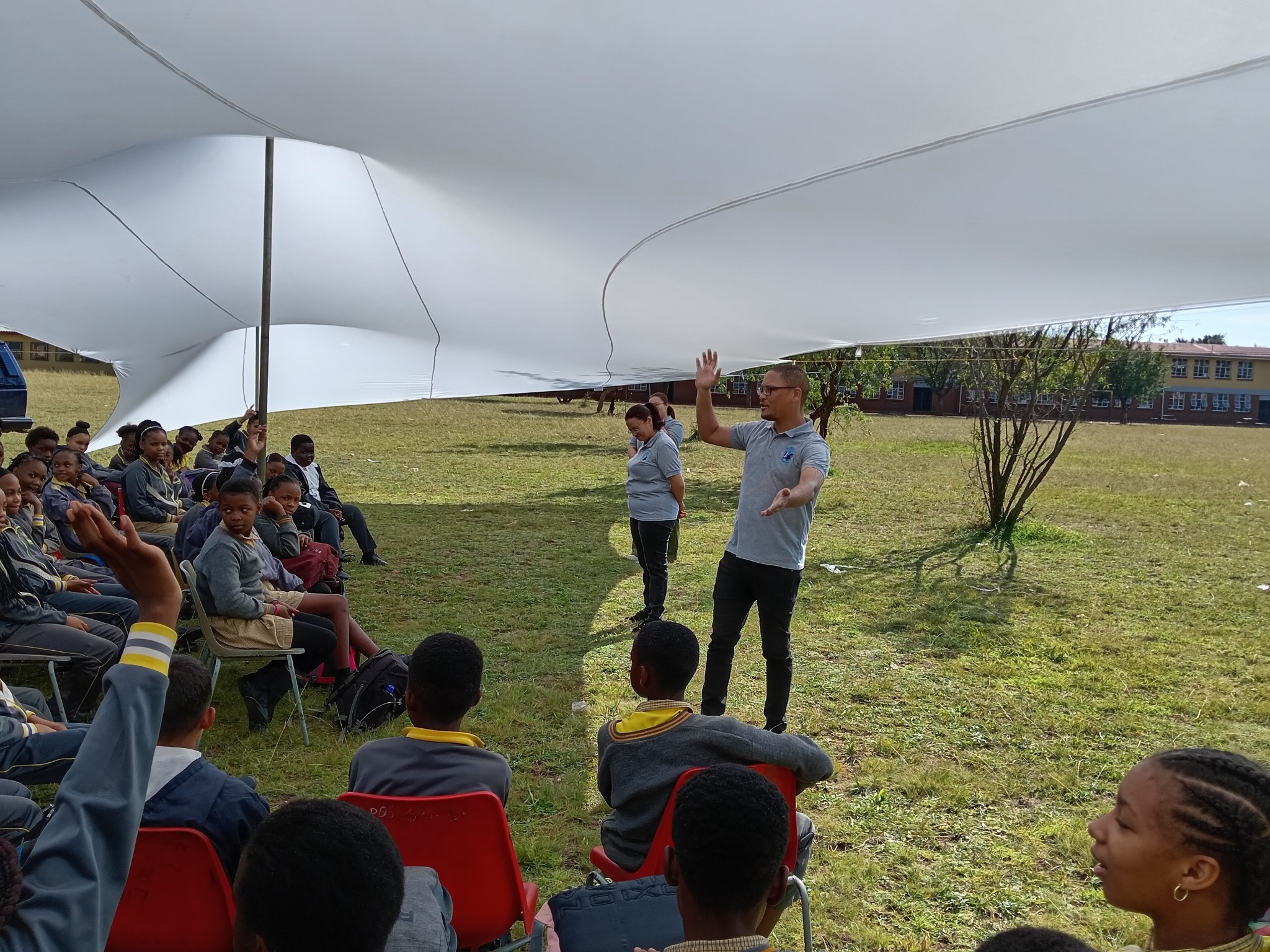 A learner raising a hand during the Poseidon Primary School leadership engagement